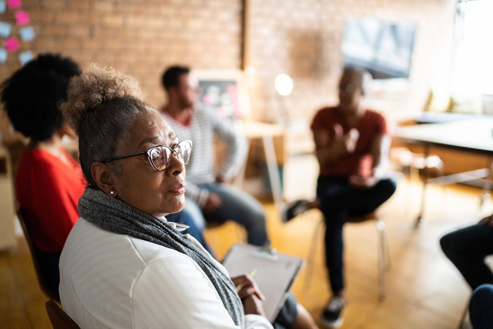 Portrait of a senior woman in group therapy or business meeting